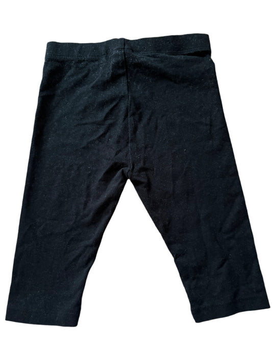 Folded black pants on a wooden surface